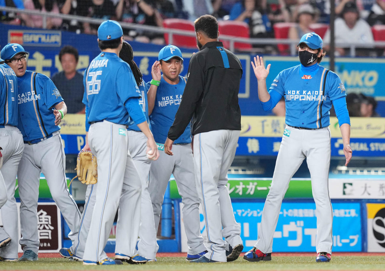 ロッテ対日本ハム　ロッテに勝利しナインをタッチで迎える日本ハム新庄監督（右）（撮影・横山健太）