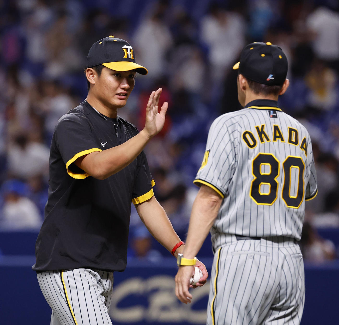 中日対阪神　中日に勝利し、岡田監督（右）とタッチを交わす西純（撮影・藤尾明華）