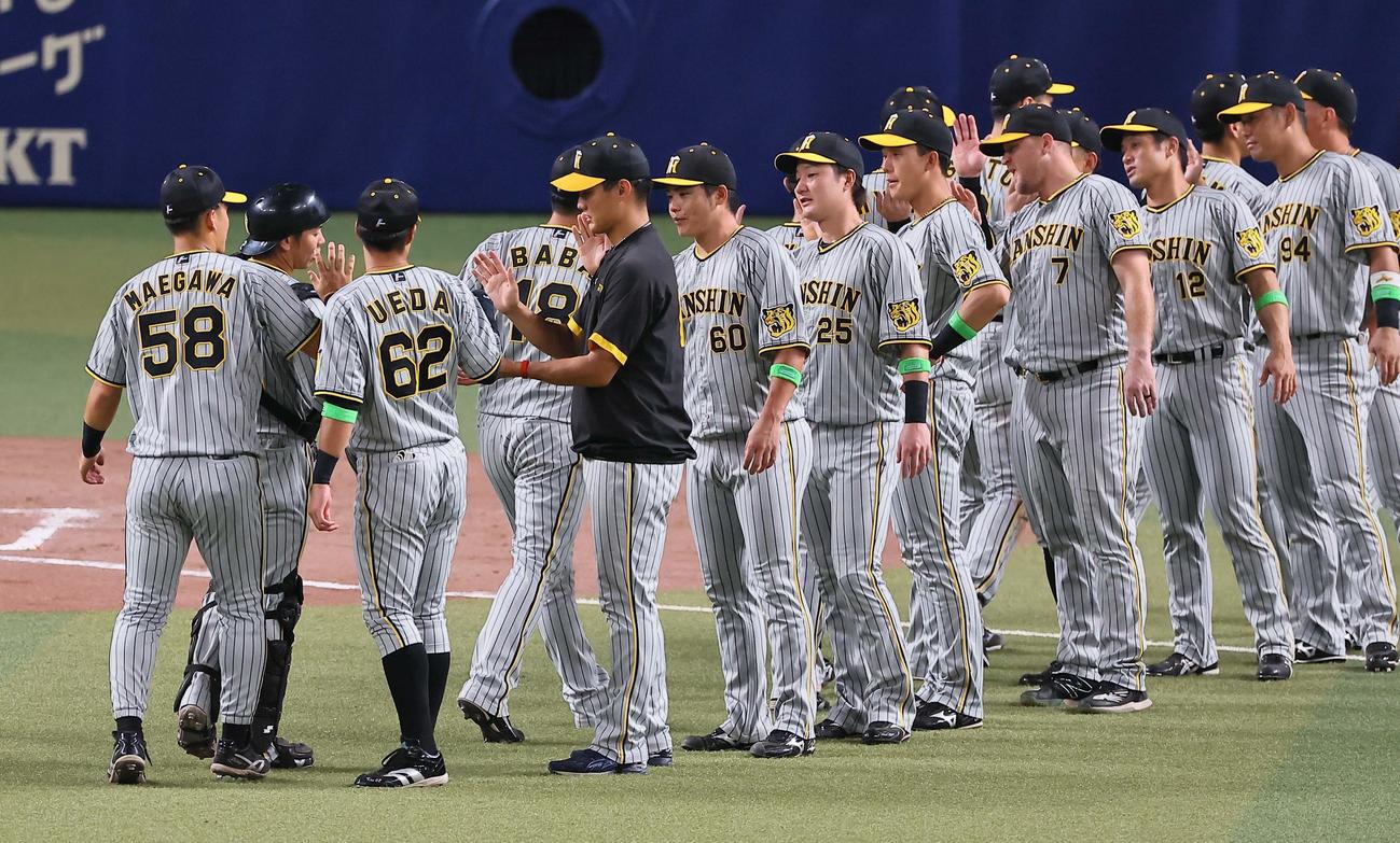 中日対阪神　4勝目をあげた西純（左から4人目）は梅野隆太郎から勝利球を受け取る（撮影・上田博志）
