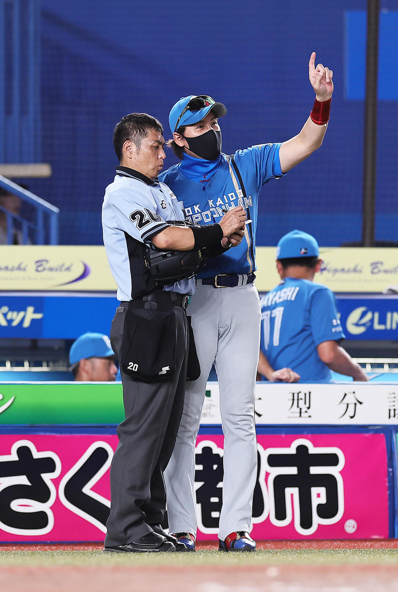 ロッテ対日本ハム　選手交代を告げる日本ハム新庄監督。左は白井球審（撮影・足立雅史）