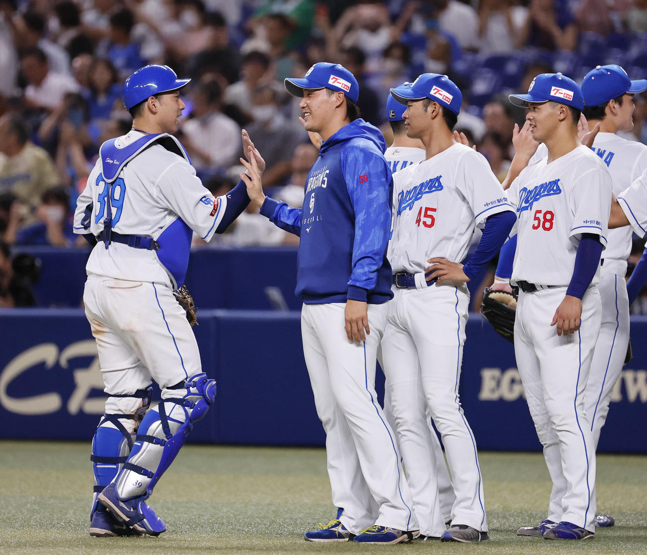 中日対阪神　移籍後初勝利を飾り、ナインとタッチを交わす斎藤（左から2人目）（撮影・藤尾明華）