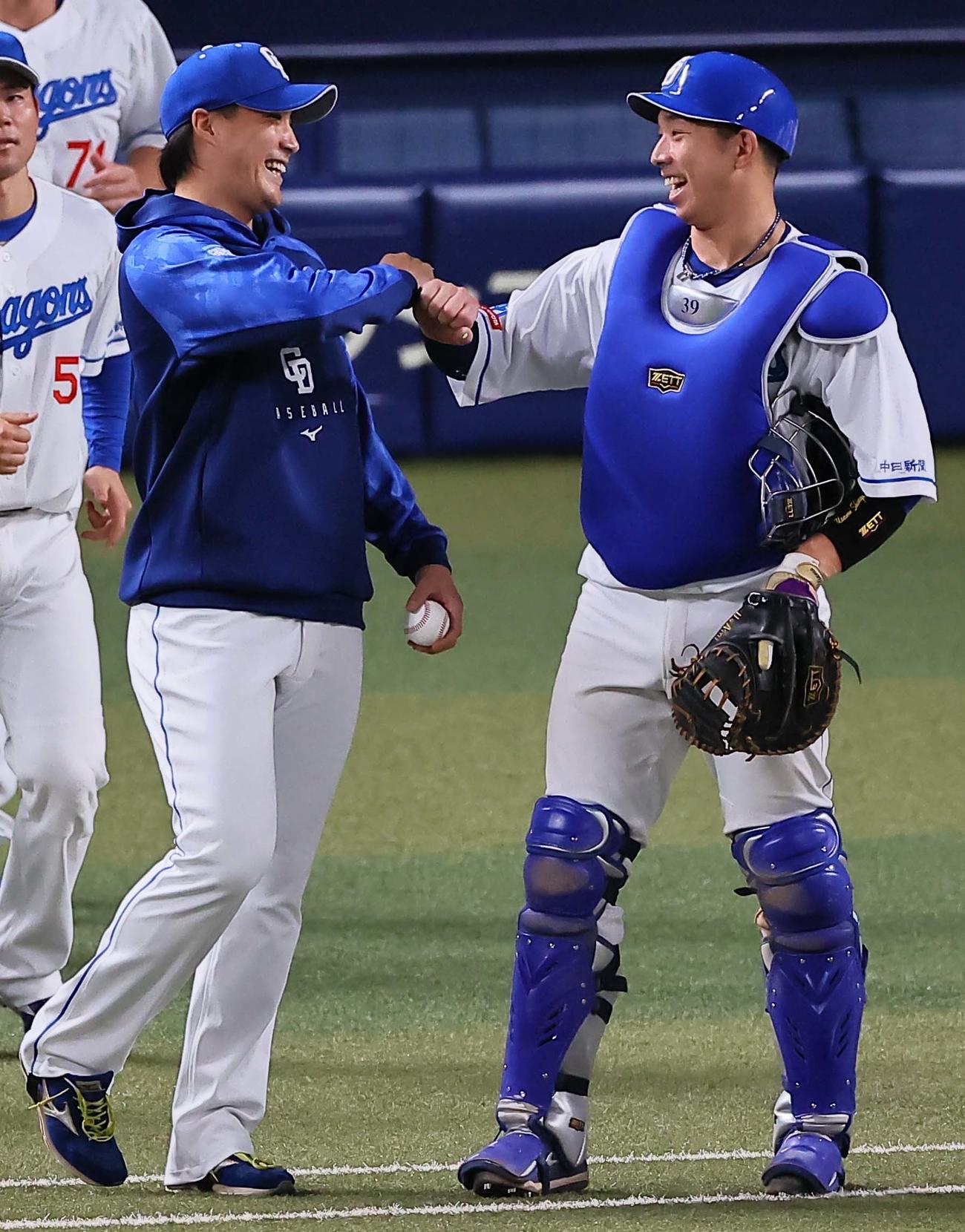 中日対阪神　移籍後初勝利をあげた斎藤（左）は宇佐見と笑顔を見せながらグータッチをする（撮影・上田博志）