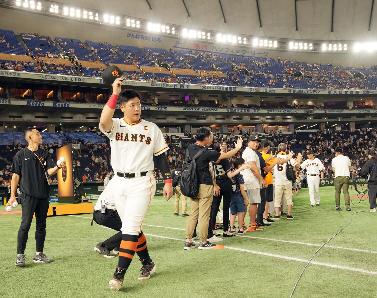 巨人対ヤクルト　ヒーローインタビュー後、ファンにあいさつする岡本和（左）。後方右は坂本（撮影・狩俣裕三）
