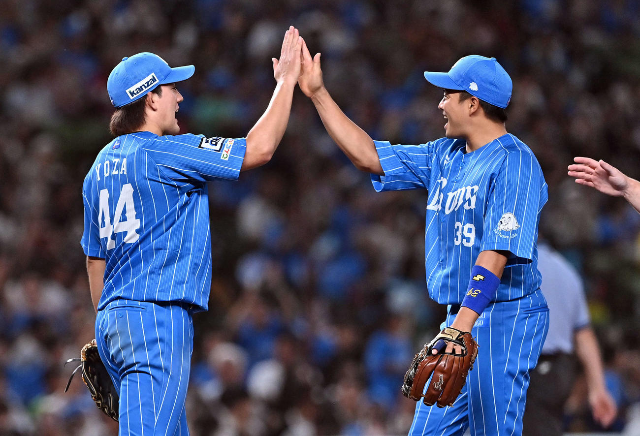 西武対ソフトバンク　完封勝利した西武与座（左）は呉とタッチをかわす（撮影・滝沢徹郎）