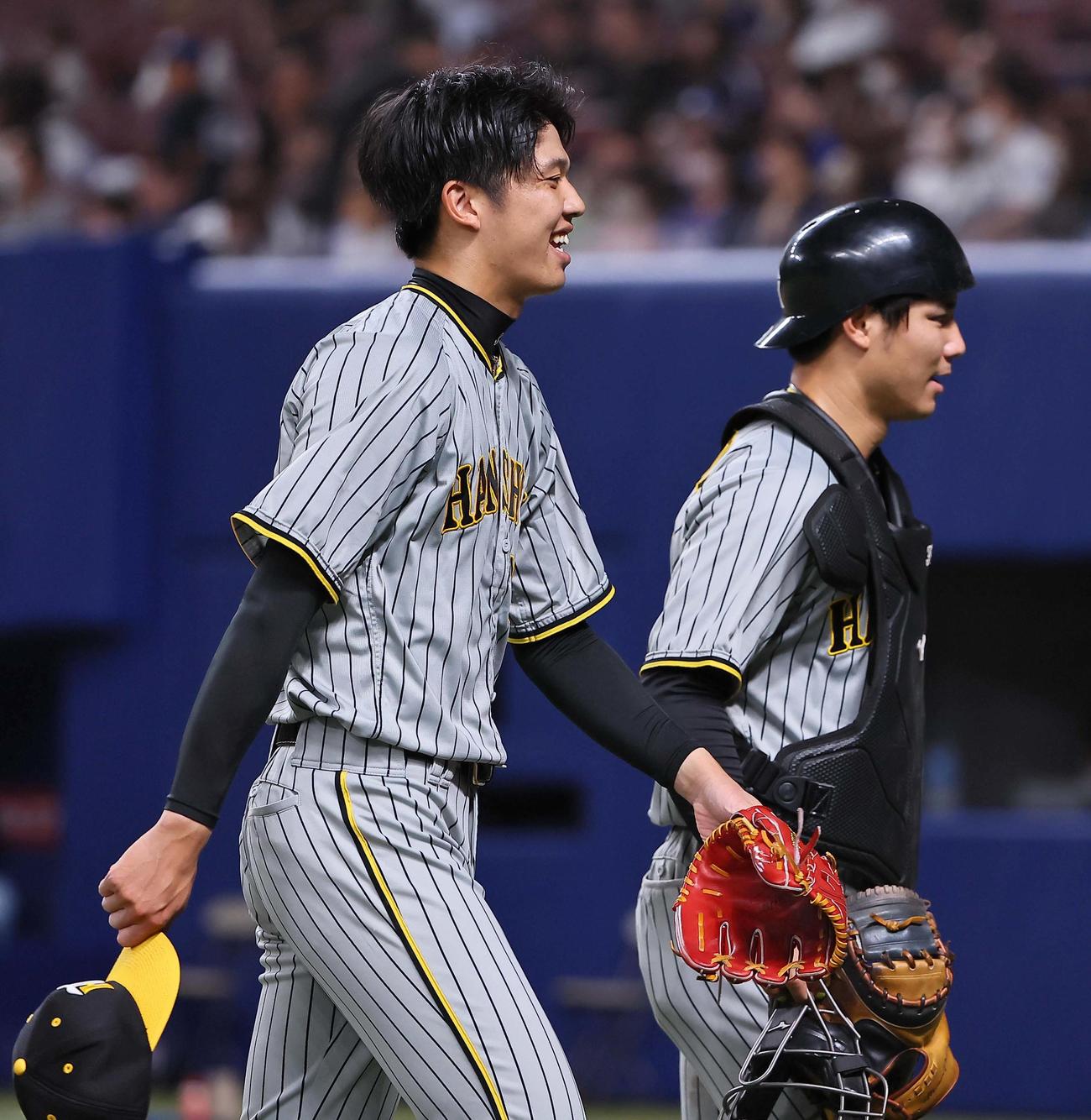 ウエスタン中日対阪神　3回を無安打に抑えた才木（左）は笑顔を見せながらベンチに引き揚げる。右は栄枝（撮影・上田博志）