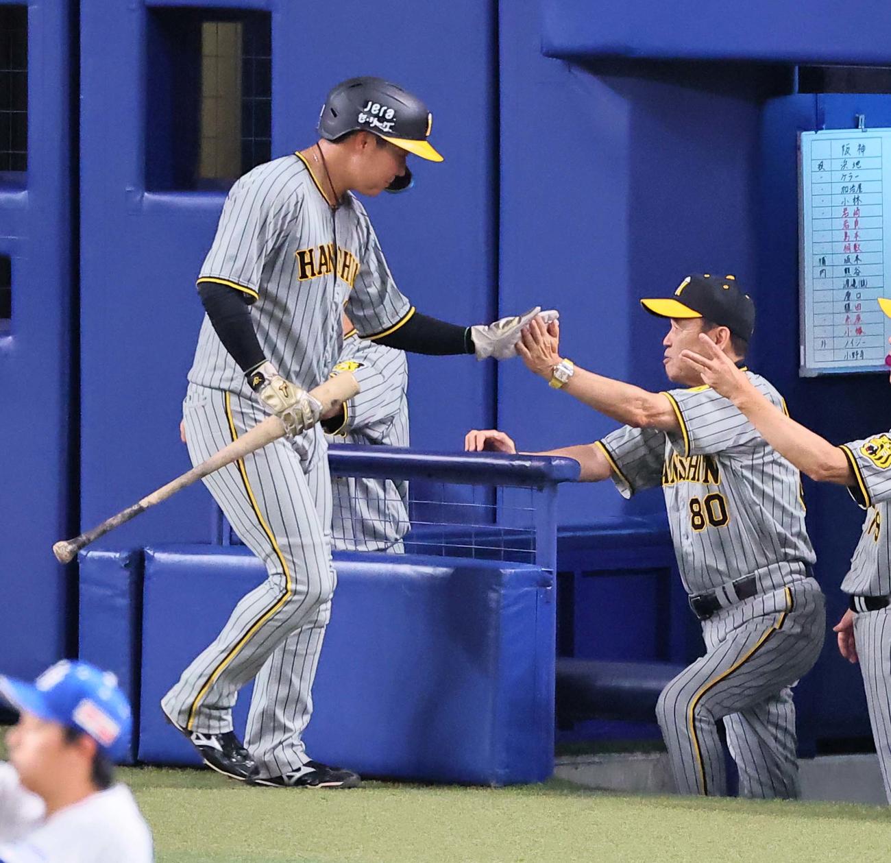 中日対阪神　5回表阪神無死一、三塁、島田の適時打で生還した大山（左）をハイタッチで出迎える岡田監督（撮影・上田博志）