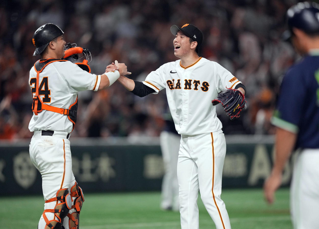 巨人対ヤクルト　試合後、大城（左）とタッチを交わし、喜び合う戸郷（撮影・狩俣裕三）