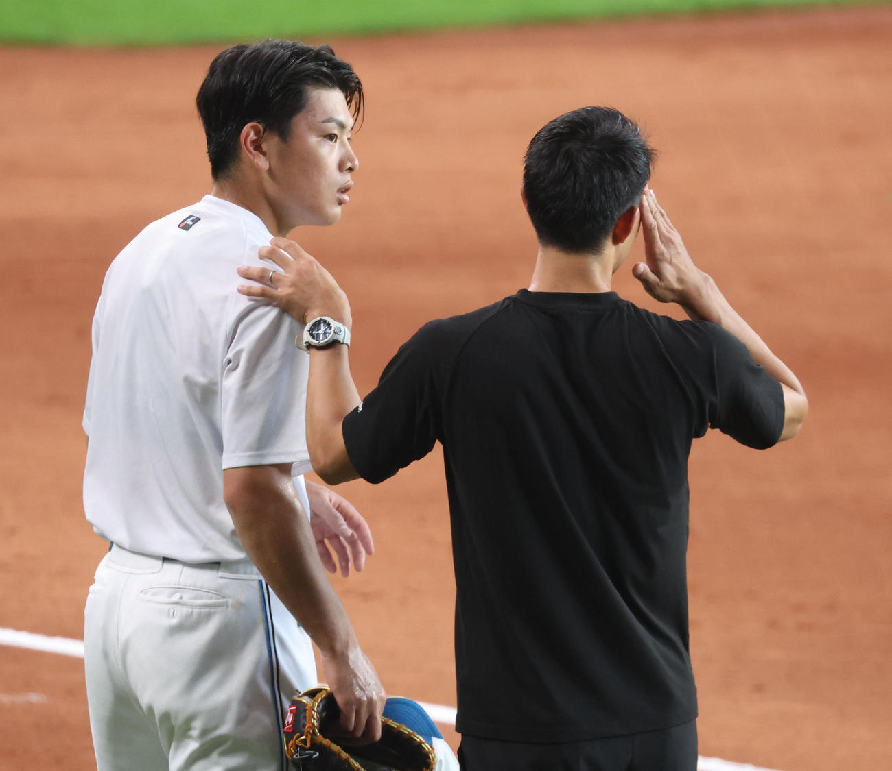 日本ハム対ソフトバンク　練習中の打球が当たり、トレーナーに確認してもらう日本ハム野村（撮影・佐藤翔太）