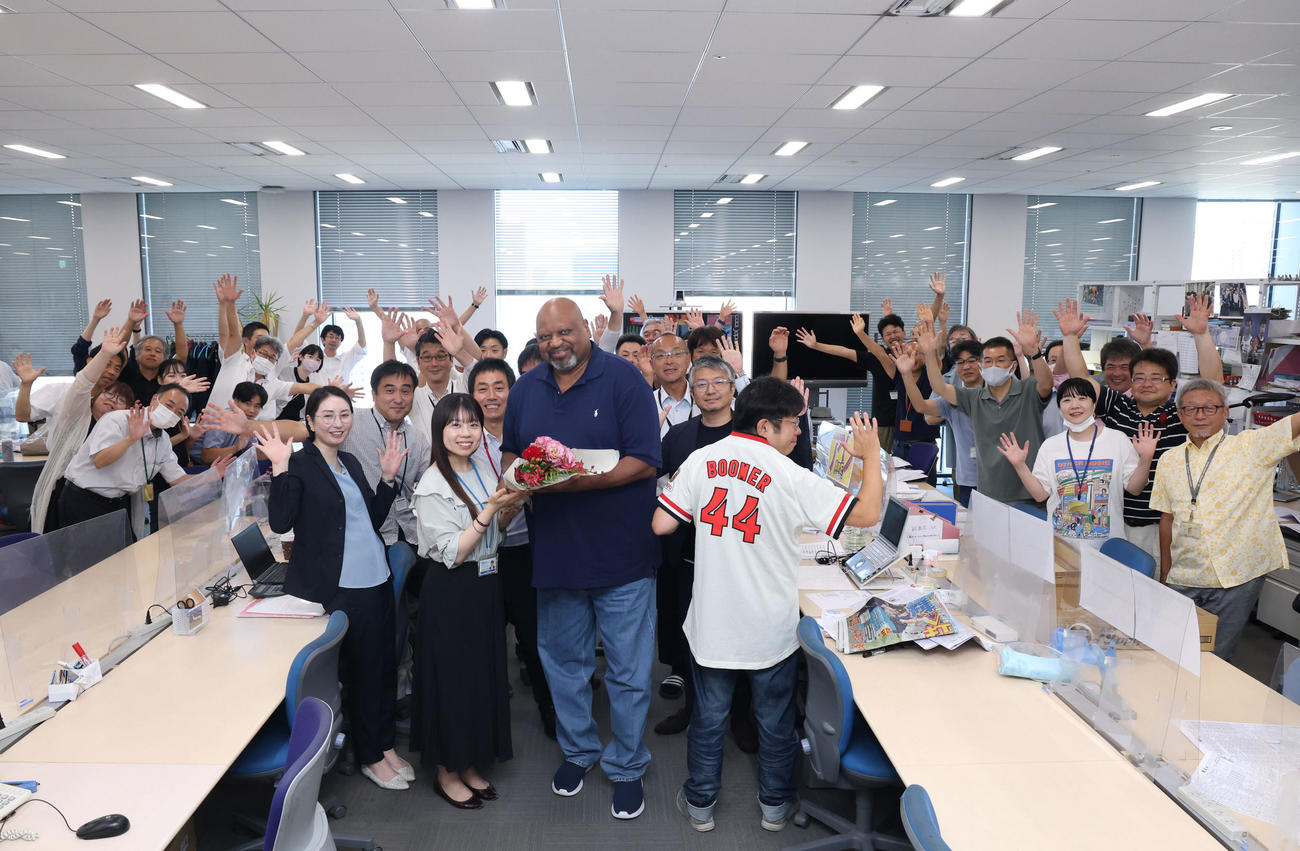 日刊スポーツ大阪本社を訪れ、社員から花束を受け取り笑顔を見せるブーマー氏（撮影・藤尾明華）