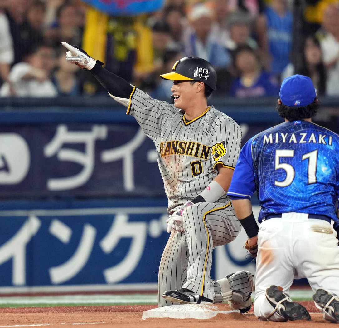 8回表阪神2死一、二塁、2点適時二塁打と相手失策で三塁に進み、ベンチに向かって笑顔を見せる木浪（撮影・狩俣裕三）