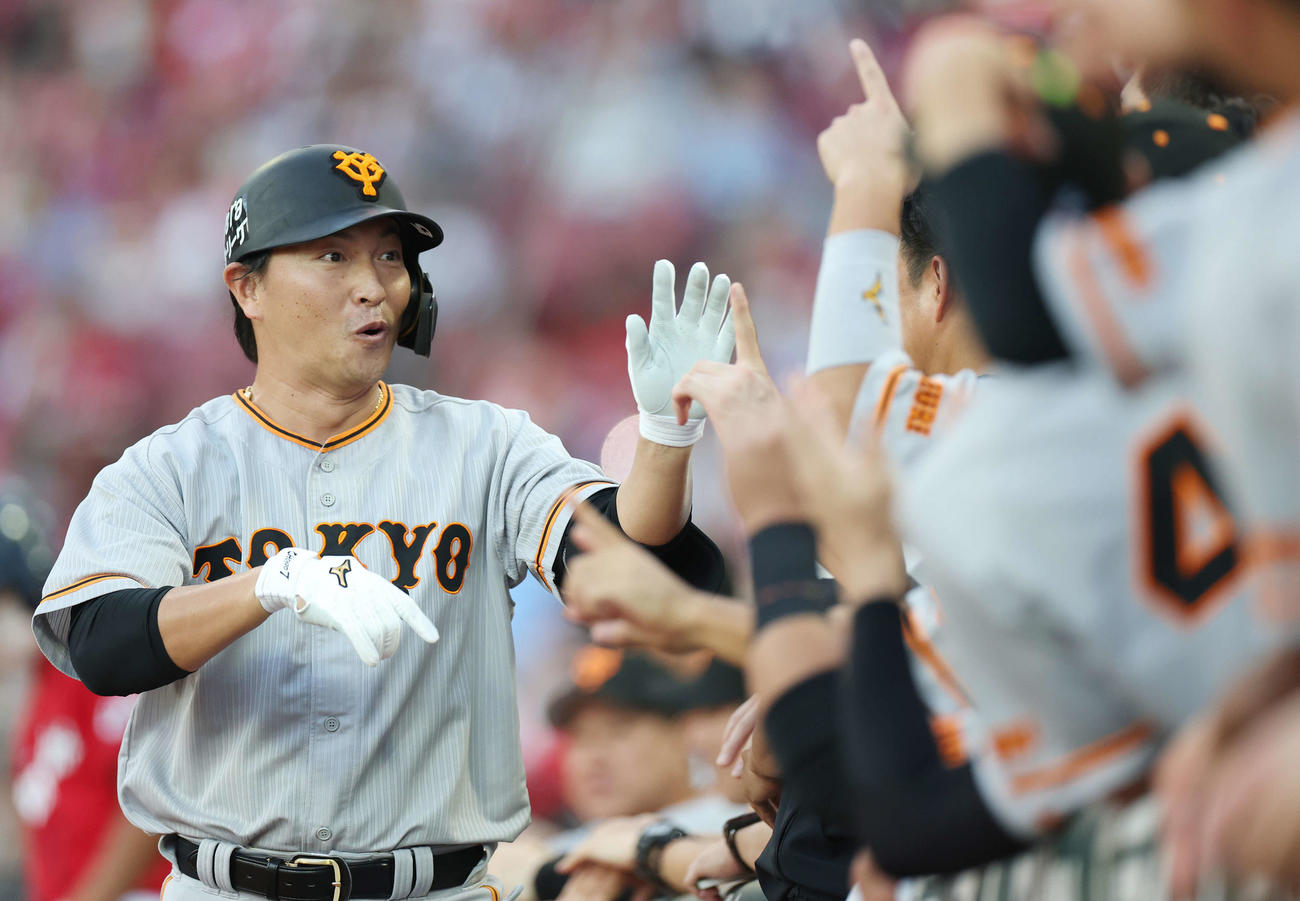 広島対巨人　2回表巨人無死、ソロ本塁打を放った長野は驚いた表情でタッチを交わす（撮影・宮地輝）
