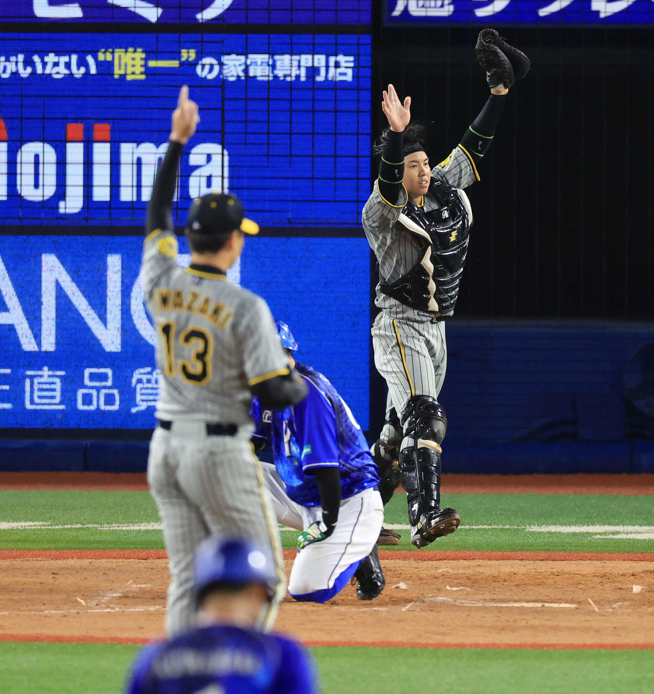 DeNA対阪神　9回裏DeNA2死一塁、関根を捕邪飛に仕留めて4連勝を決めバンザイする梅野（奥）。手前は岩崎（撮影・浅見桂子）