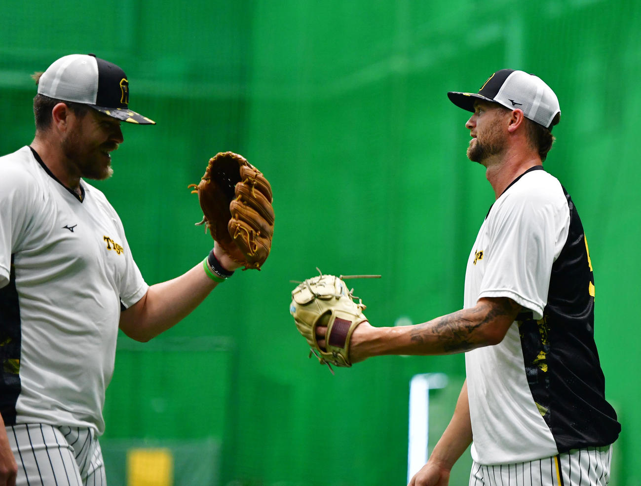 キャッチボールを終えビーズリー（左）とグラブタッチする阪神新外国人のブルワー（撮影・清水貴仁）