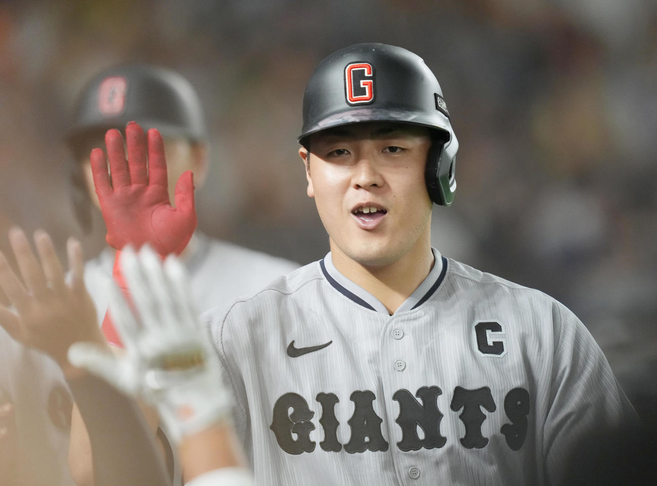 巨人対阪神　6回裏巨人1死一塁、2点本塁打を放ち、ベンチのチームメートとタッチを交わす岡本和（撮影・狩俣裕三）