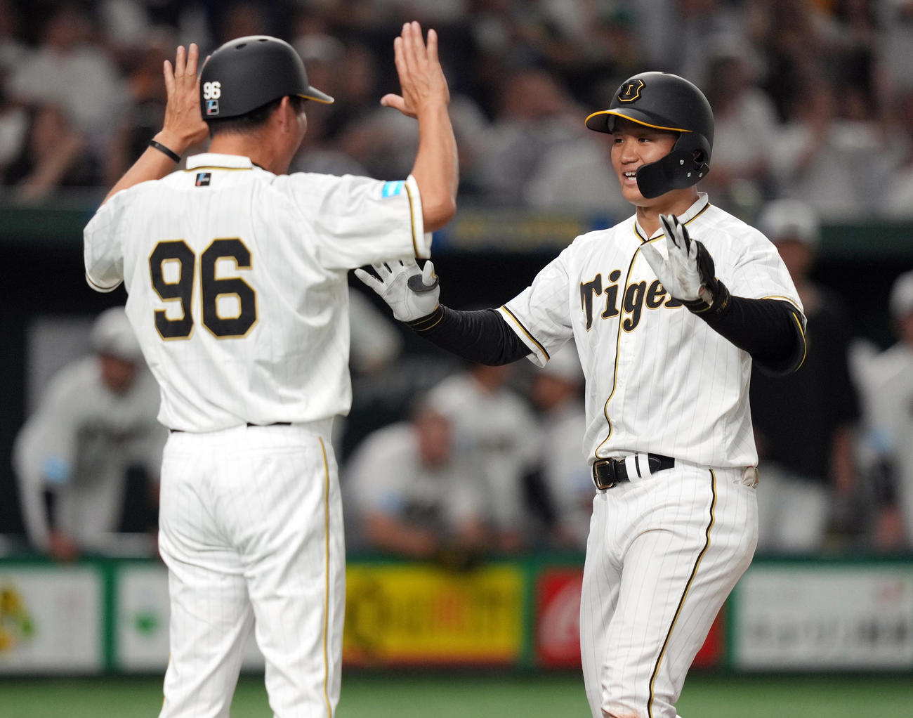 巨人対阪神　8回表阪神1死一塁、2点本塁打を放ち、本塁で迎える筒井コーチ（左）とタッチを交わす森下（撮影・狩俣裕三）