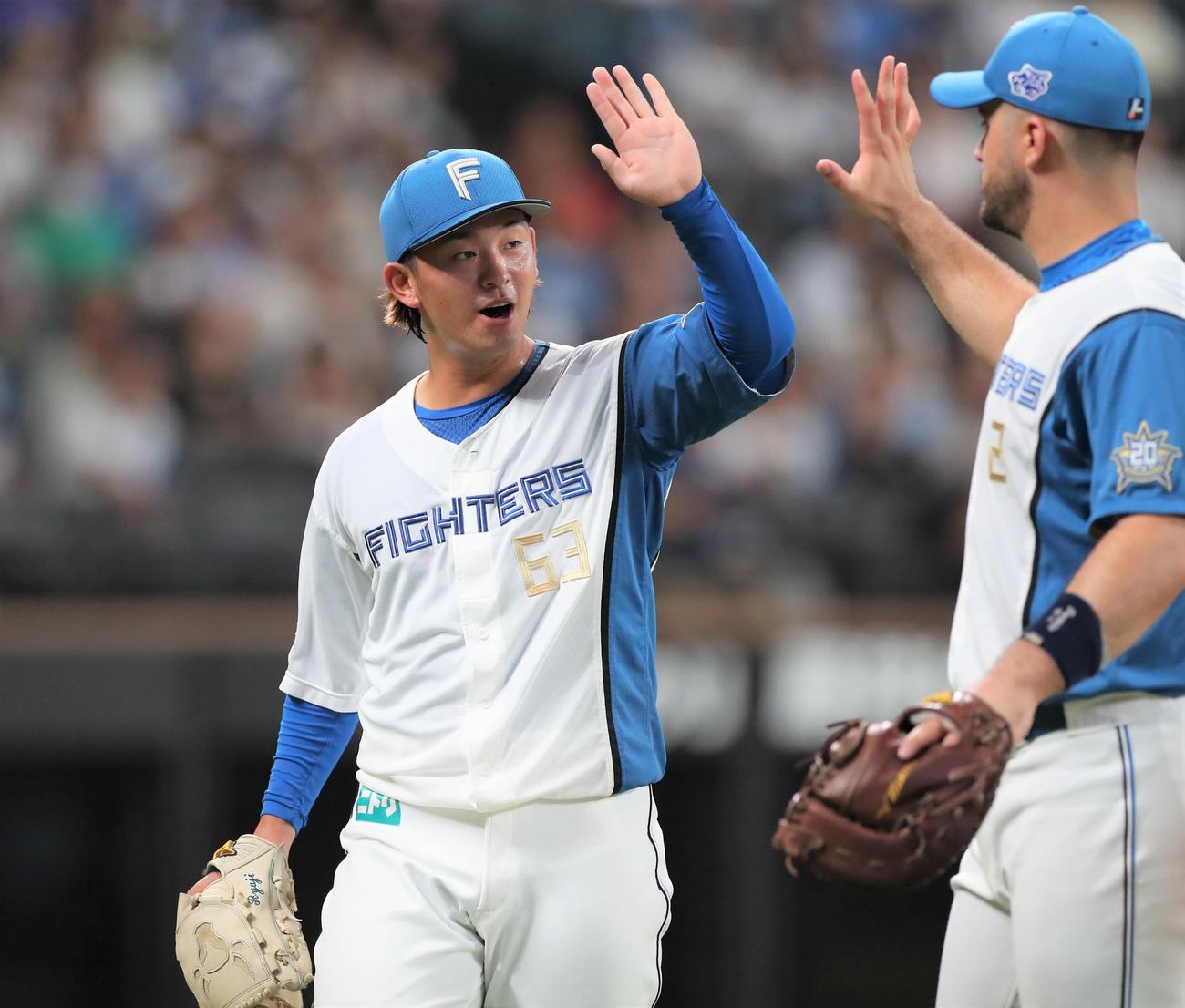日本ハム対西武　8回表、打者を3人で抑えマルティネスとタッチする北浦（撮影・黒川智章）
