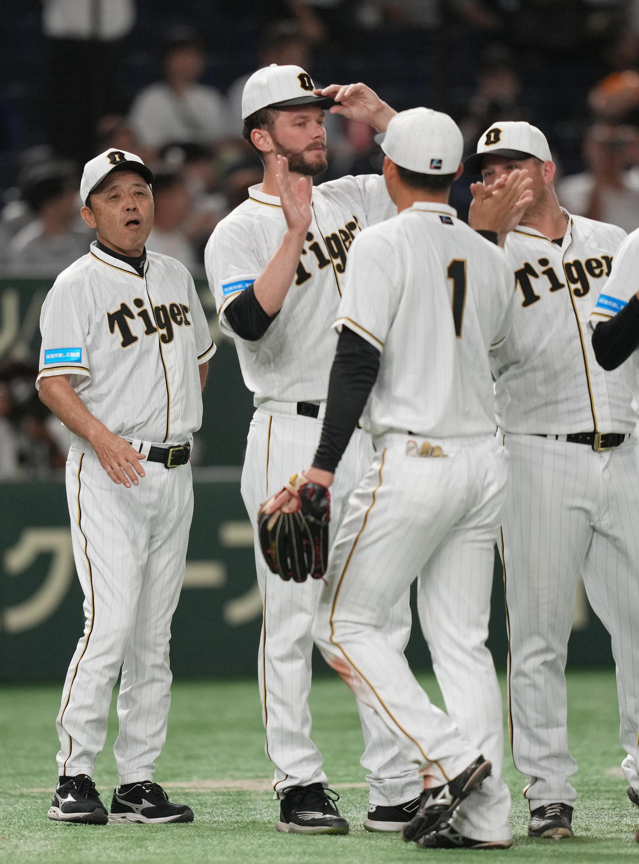 巨人対阪神　接戦を制し、森下（手前）ら選手を迎える岡田監督（左）（撮影・狩俣裕三）