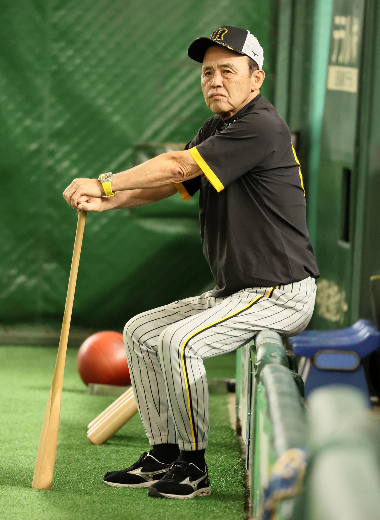 巨人対阪神　ベンチのフェンスに腰掛ける岡田監督（撮影・加藤哉）