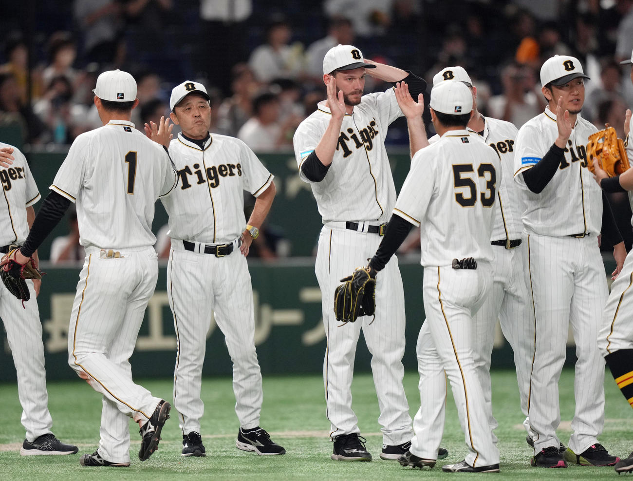 巨人対阪神　接戦を制し、森下（左端）ら選手とタッチを交わす岡田監督（左から2人目）（撮影・狩俣裕三）