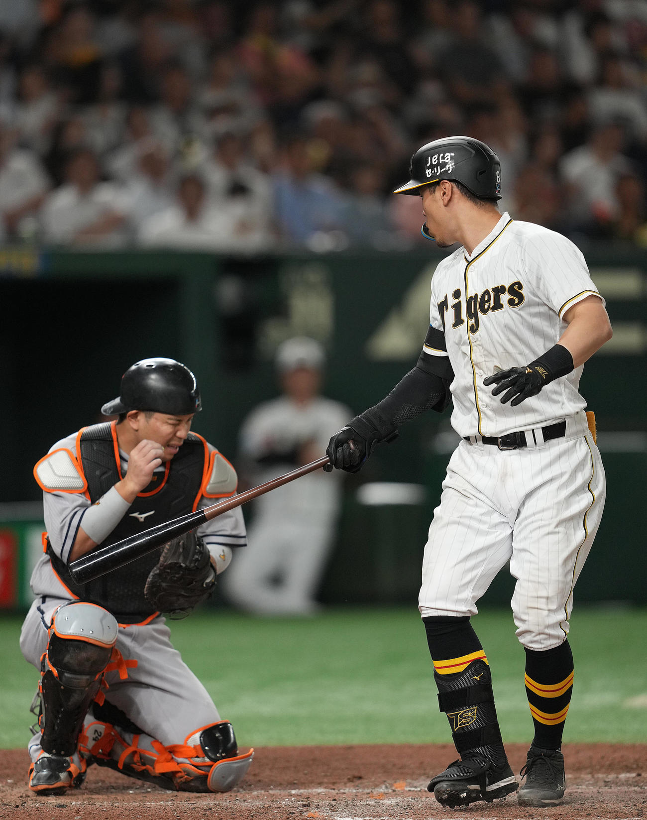 巨人対阪神　6回表阪神1死一、二塁、佐藤輝（右）の空振りしたバットが右目付近に当たり、痛がる大城（撮影・狩俣裕三）