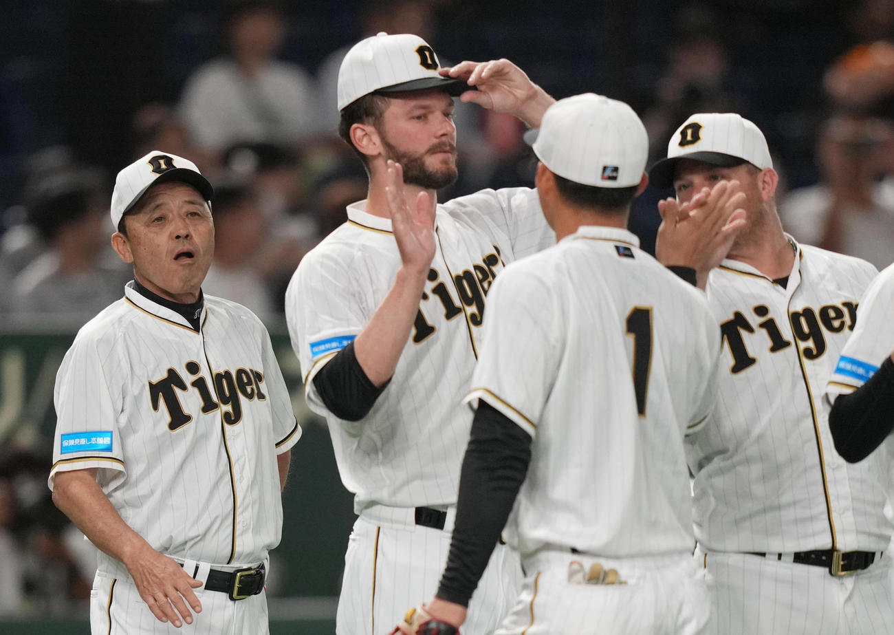 接戦を制し、森下（手前）ら選手を迎える岡田監督（左）（撮影・狩俣裕三）