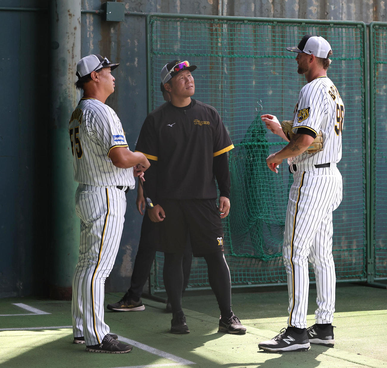 鳴尾浜のブルペンで投球練習を終え、福原コーチ（左）と話す阪神ブルワー（撮影・白石智彦）