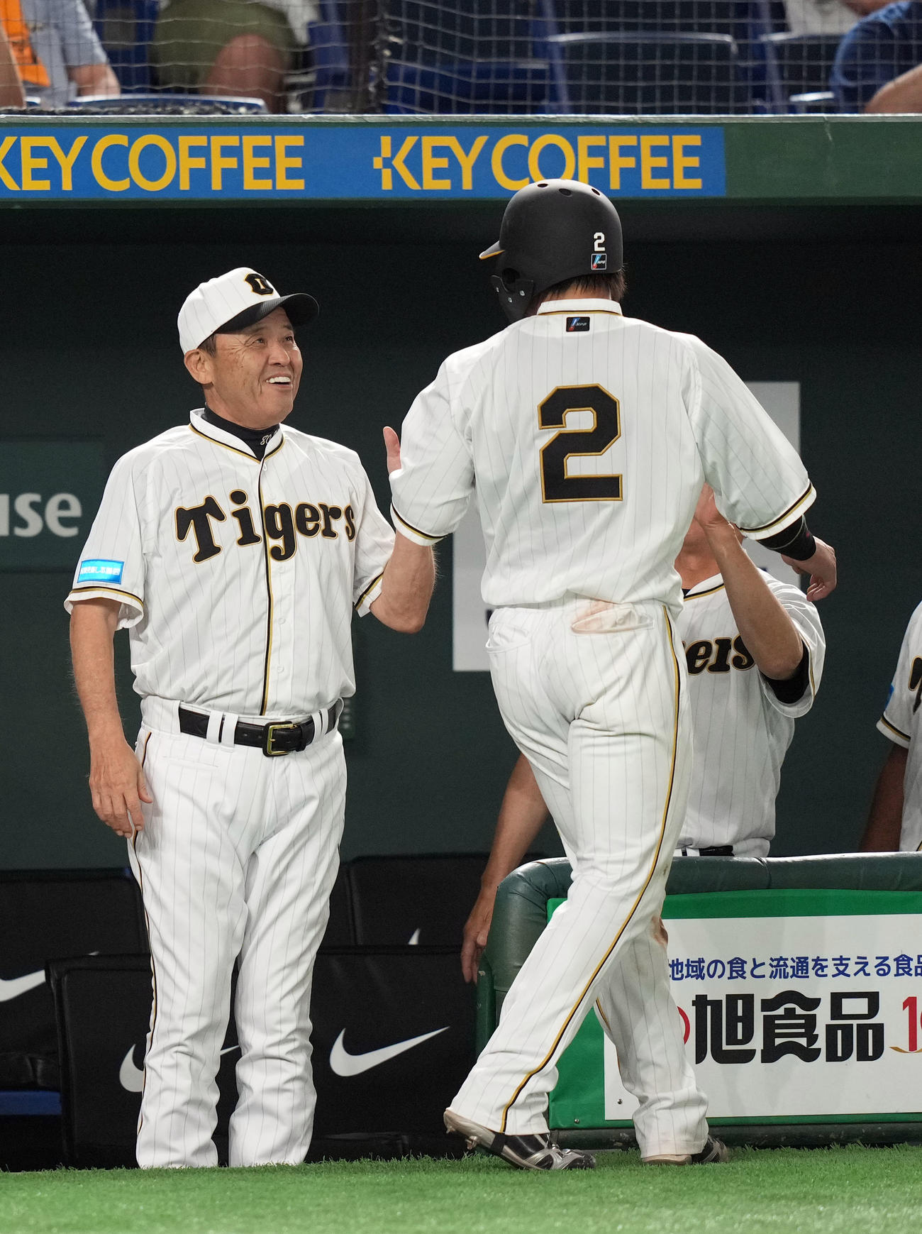 巨人対阪神　11回表阪神2死一、二塁、木浪の2点適時二塁打で生還した梅野（右）を笑顔で迎える岡田監督（撮影・狩俣裕三）
