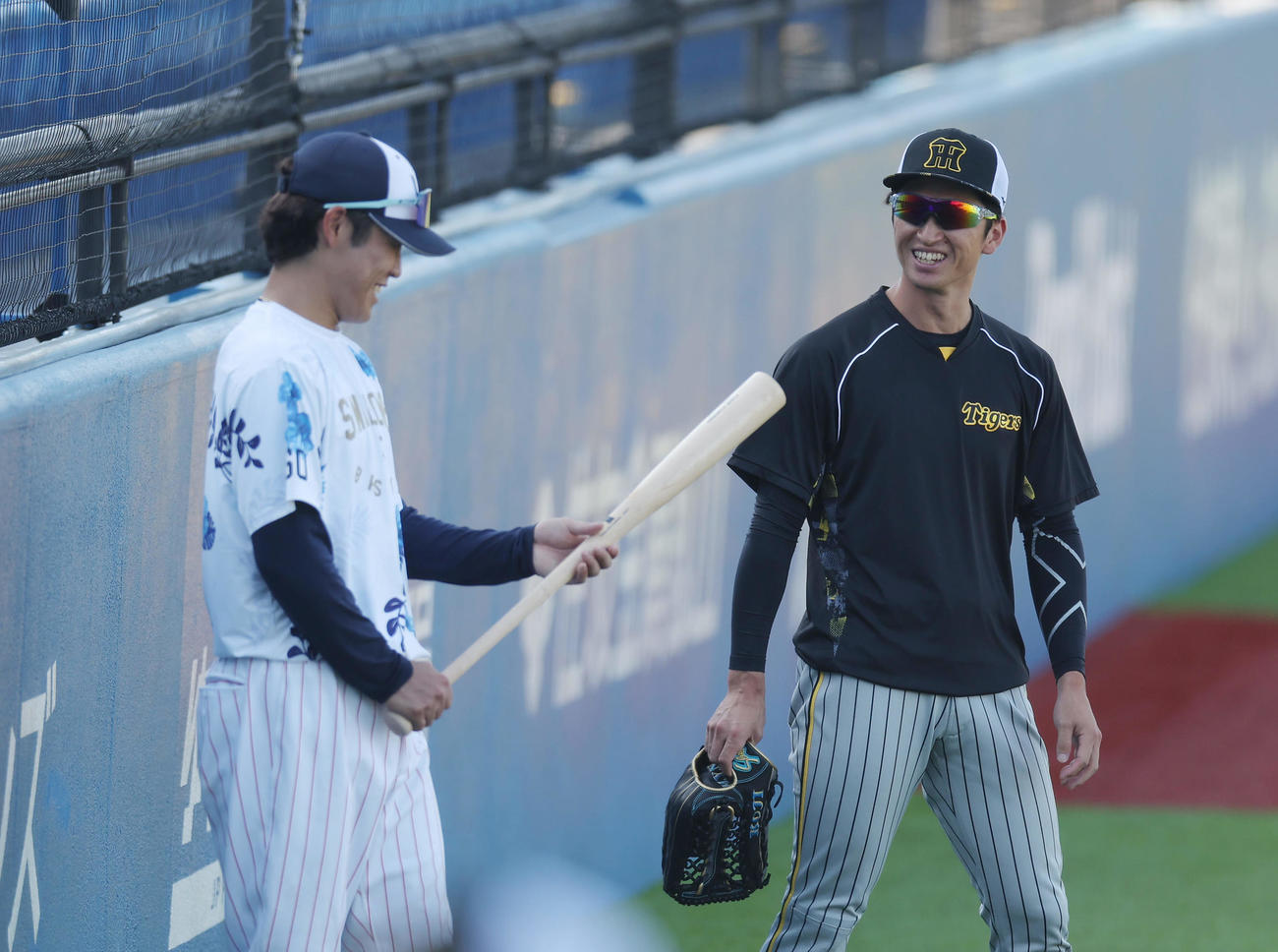 ヤクルト対阪神　試合前、ヤクルト武岡（左）にバットを渡す阪神近本（2023年7月23日撮影）