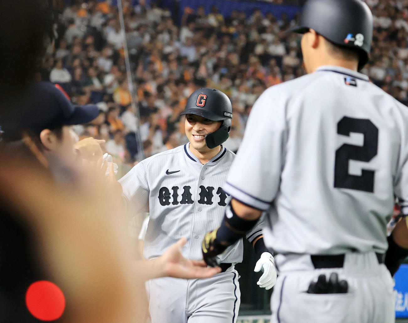巨人対阪神　3回裏巨人無死一、三塁、吉川（手前）の二塁ゴロ併殺の間に先制の生還をした長野は笑顔でナインとハイタッチ（撮影・浅見桂子）