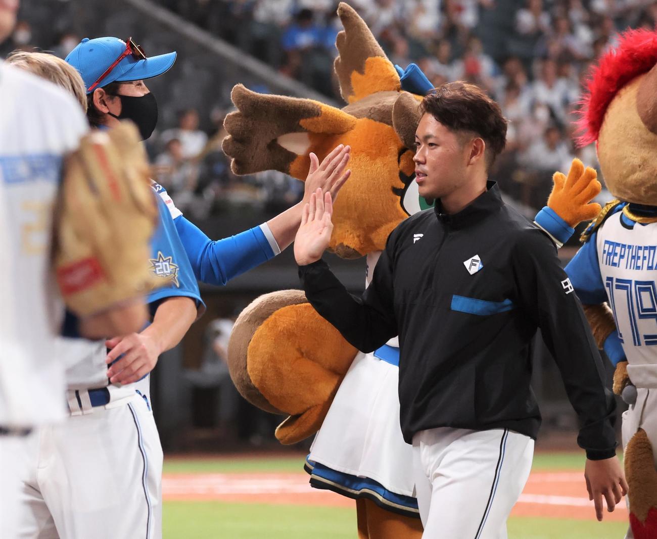 日本ハム対西武　試合後、根本を出迎える新庄監督（撮影・黒川智章）