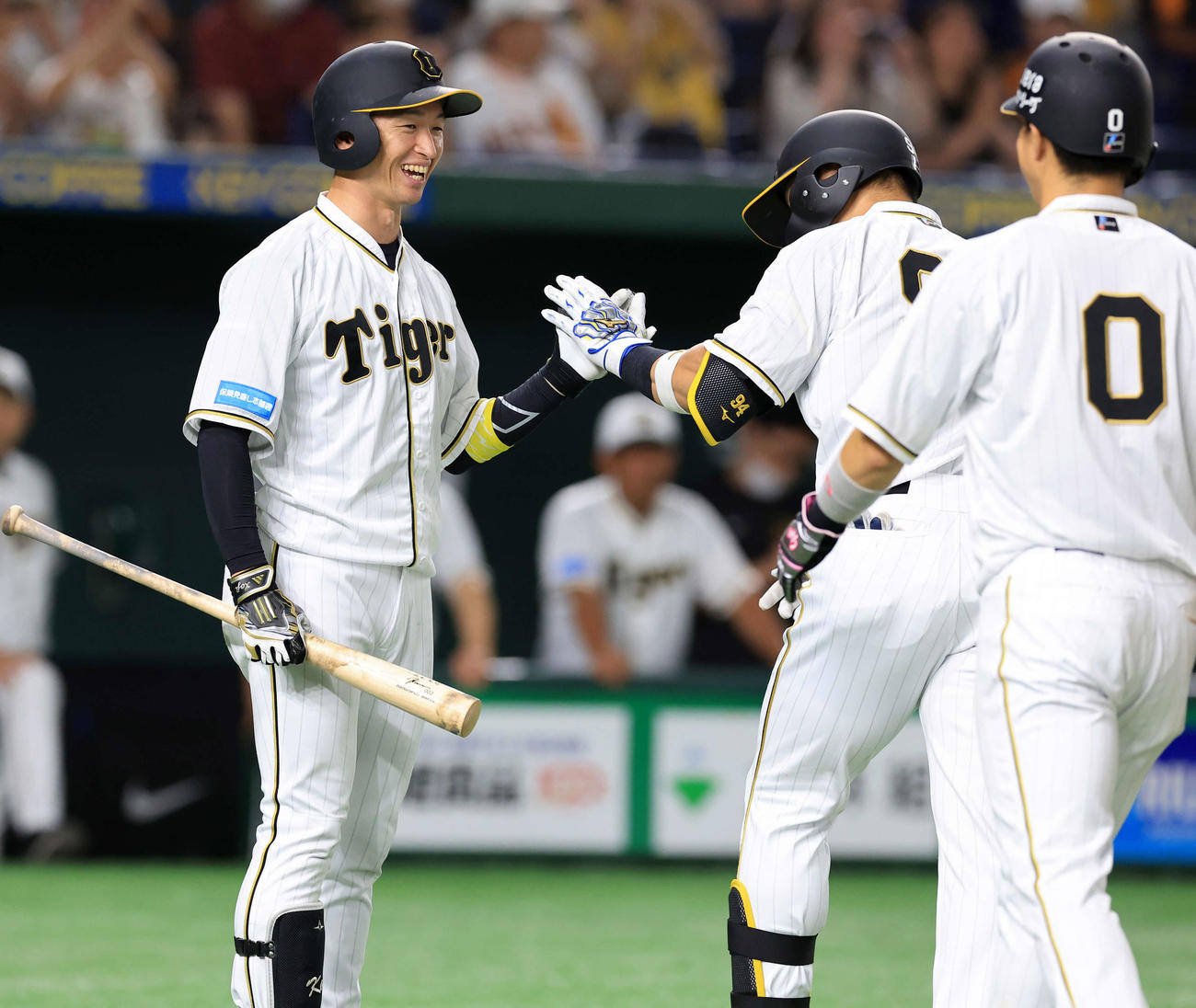 巨人対阪神　9回表阪神1死一塁、原口（右奥）が左中間2点本塁打を放ち、笑顔で迎える近本（左）（撮影・浅見桂子）