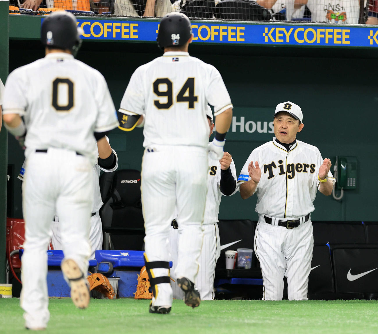 巨人対阪神　9回表阪神1死一塁、原口（手前右）が左中間2点本塁打を放ち、拍手で迎える岡田監督（右）（撮影・浅見桂子）