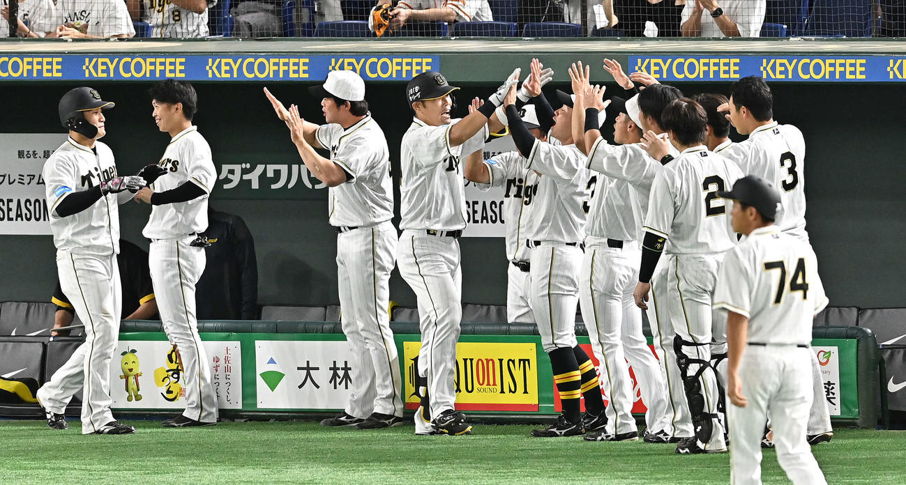 巨人対阪神　9回表阪神1死一塁、2点本塁打を放った代打の代打原口（中央）はチームメートとタッチをかわす（撮影・滝沢徹郎）