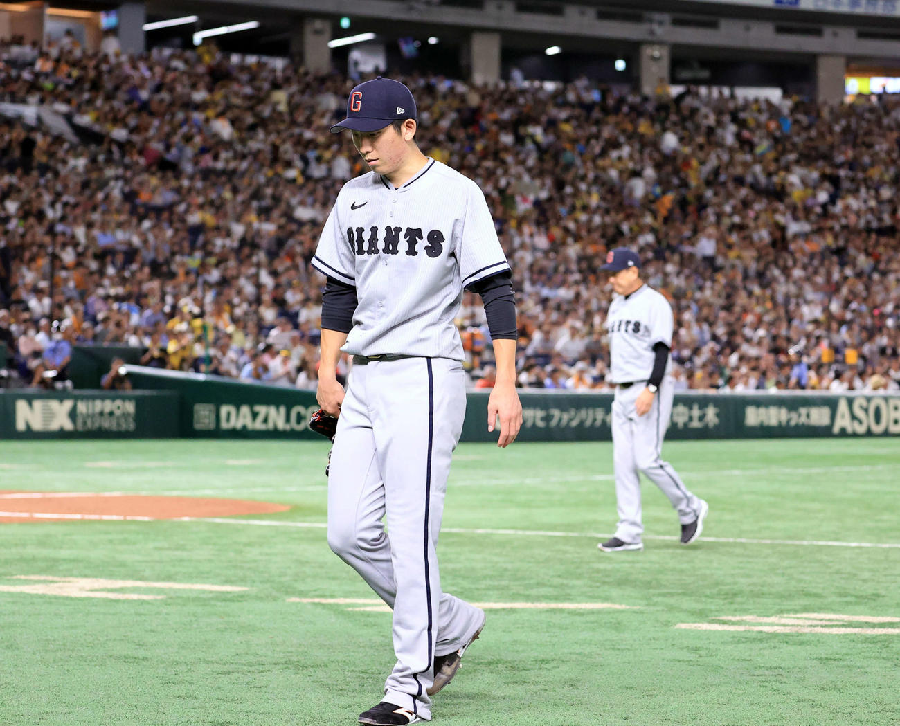 巨人対阪神　7回表阪神2死、降板を告げられうつむいて引き揚げる戸郷。奥は原監督（撮影・浅見桂子）