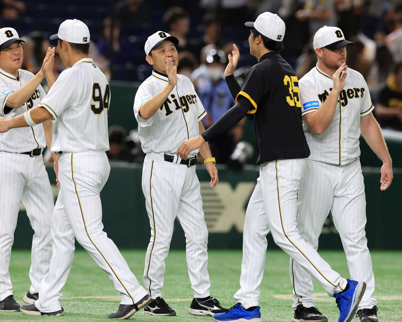 巨人対阪神　7連勝し、勝利投手の才木（手前右）らを笑顔で迎える岡田監督（中央）（撮影・浅見桂子）