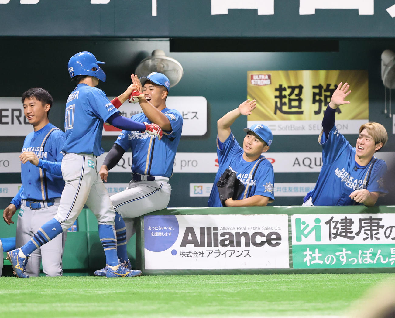 ソフトバンク対日本ハム　1回表日本ハム2死一、二塁、五十幡（左から2人目）は万波の先制左前適時打により生還しベンチのナインとタッチを交わす（撮影・冨田成美）