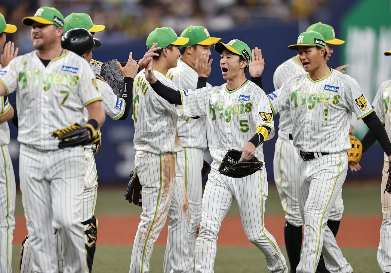 ヤクルトに勝利し、タッチを交わす近本（5）ら阪神ナイン（共同）