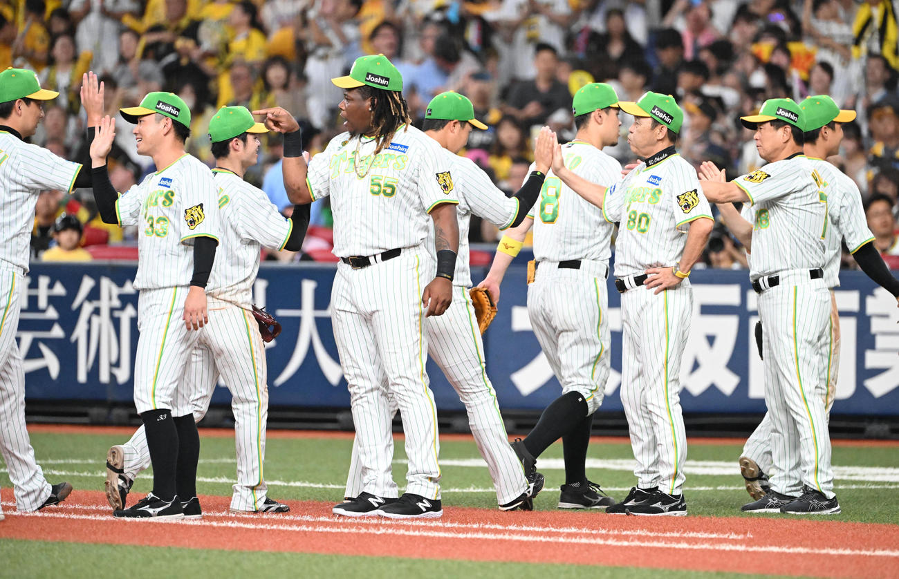 阪神対ヤクルト　ヤクルトを破り8連勝としナインをタッチで迎える阪神岡田監督（撮影・和賀正仁）