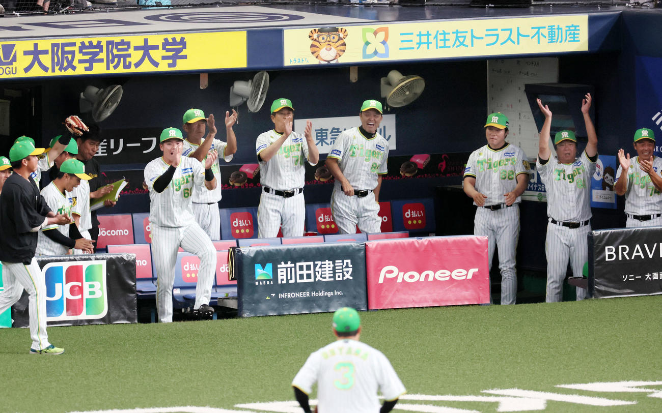 阪神対ヤクルト　8回表ヤクルト2死満塁、岡田監督（右から4人目）らはサンタナを中飛とした近本の好守に笑顔を見せる（撮影・加藤哉）