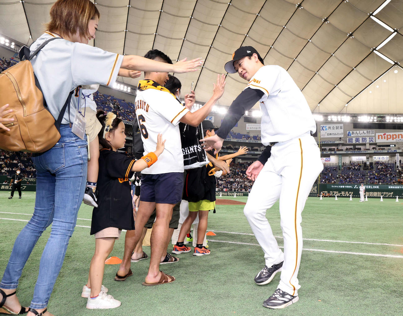 巨人対DeNA 9勝目を挙げた巨人山崎伊は、ファンの女の子らとハイタッチ（撮影・浅見桂子）