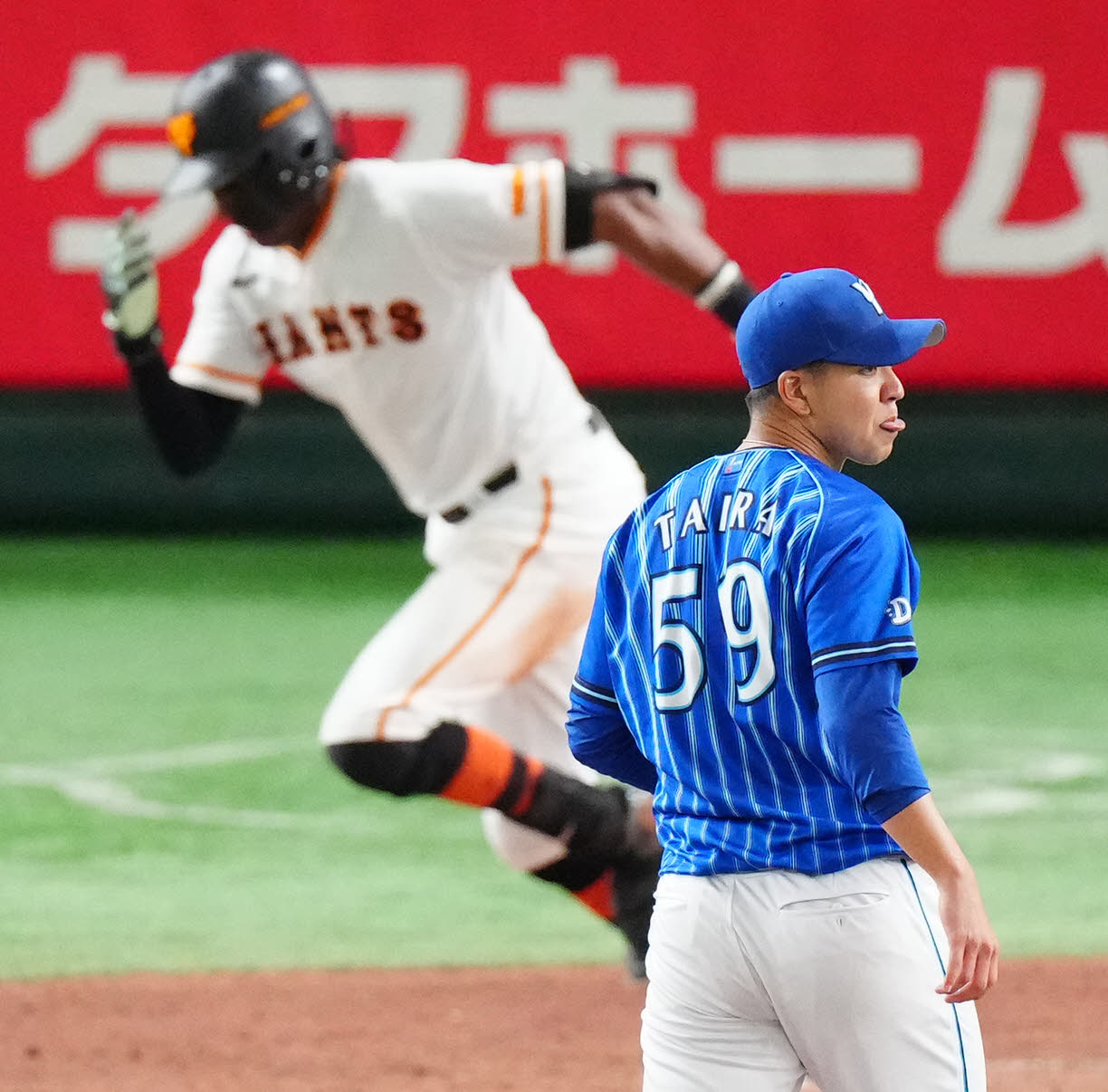 巨人対DeNA 5回裏巨人1死二、三塁、ブリンソン（後方）に先制2点適時二塁打を浴び、舌を出す平良（撮影・江口和貴）