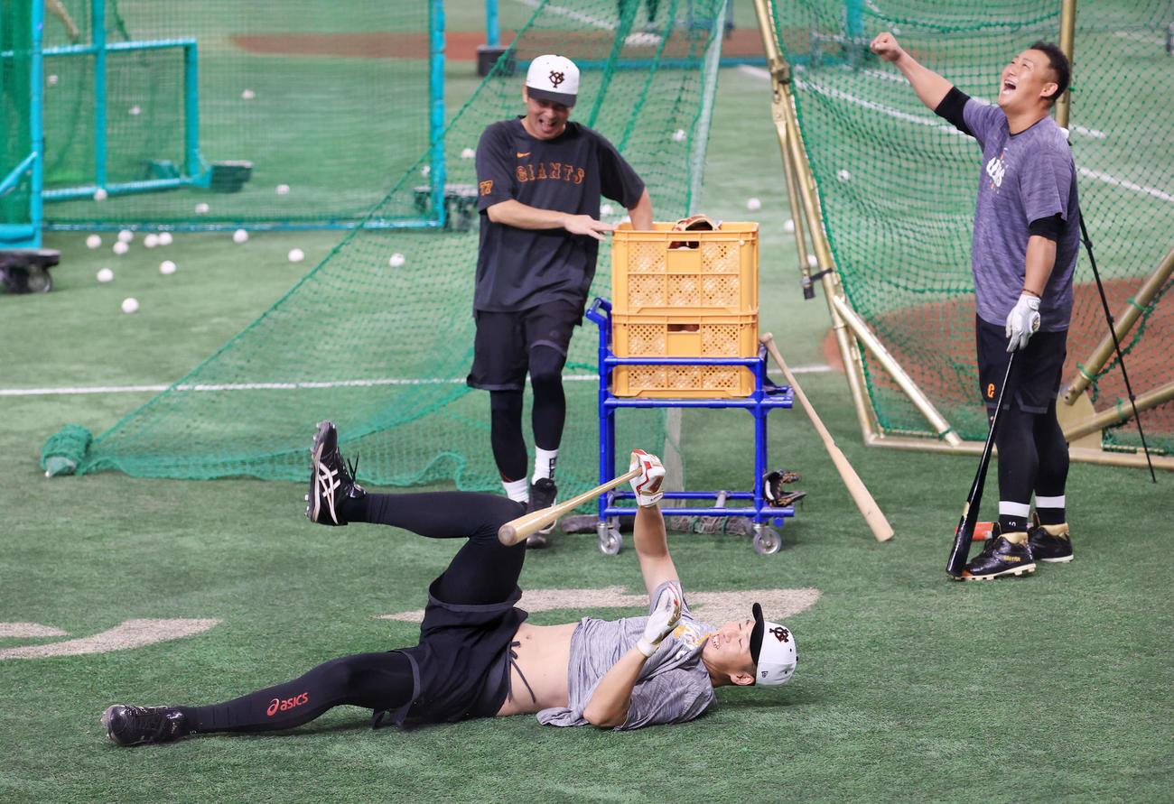 巨人対DeNA　練習中、ロングティーで勝負しながらひっくり返る巨人秋広。右は中田翔（撮影・浅見桂子）