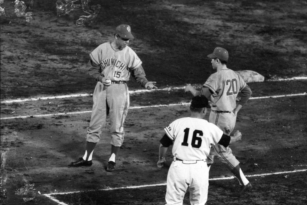1964年6月18日、中日対巨人　西沢道夫代理監督からボールを受け取る権藤博、手前は巨人川上哲治監督