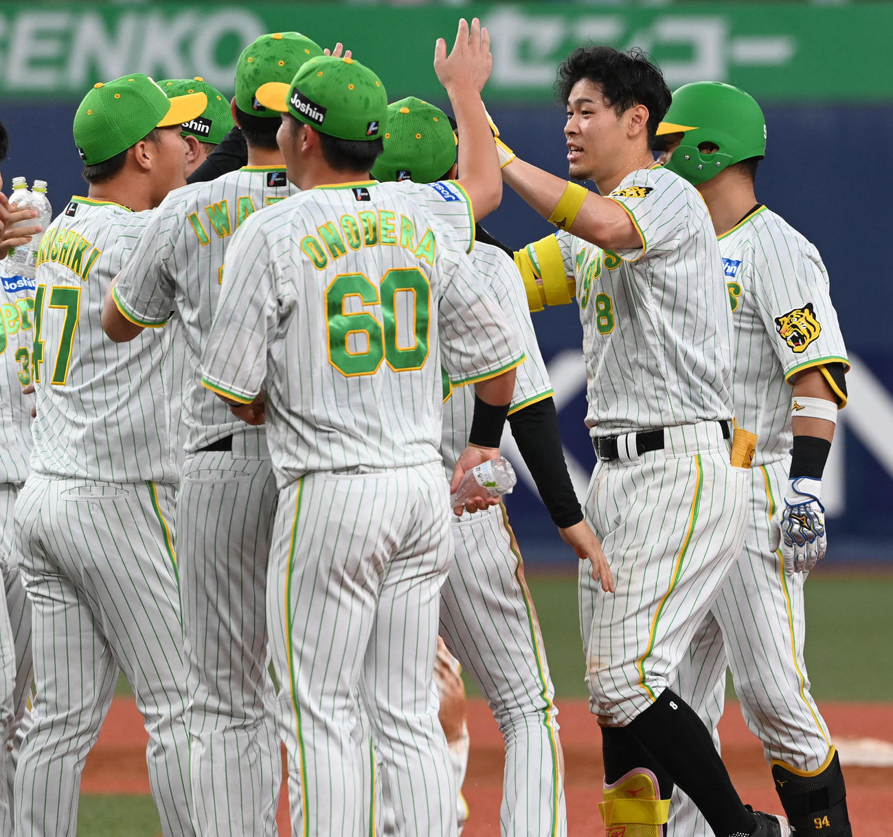 阪神対ヤクルト　12回裏阪神無死満塁、佐藤輝（右）はサヨナラ中犠飛を放ちナインの祝福を受ける（撮影・前岡正明）