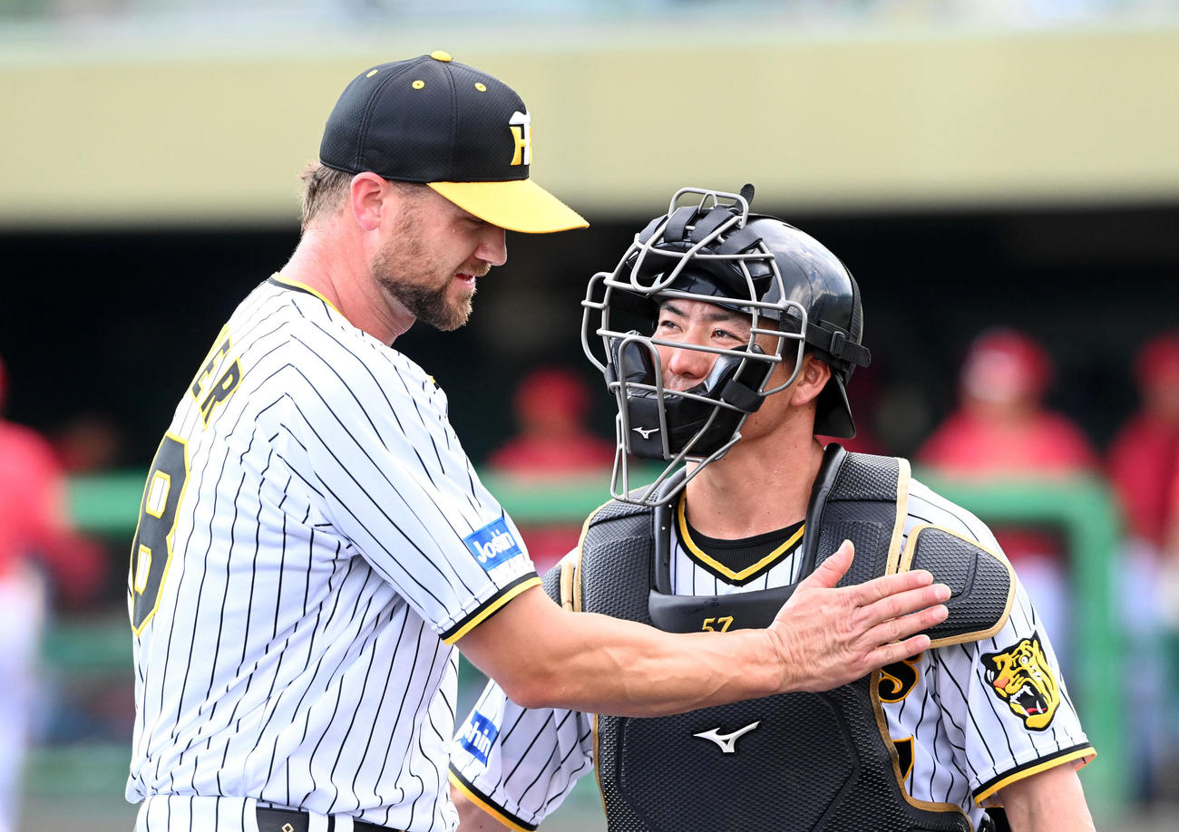 阪神対広島　広島打線を1イニング無失点に抑えた阪神ブルワー（左）は長坂と笑顔で話す（撮影・前岡正明）