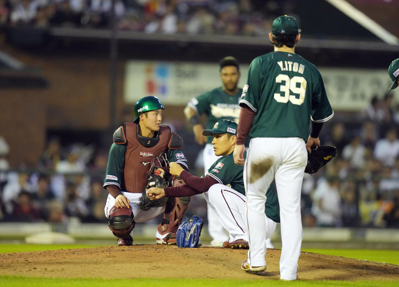 楽天対オリックス　6回表オリックス無死一塁、一塁走者太田の治療中に、マウンドに座って待つ楽天先発の則本昂大（中央）。左は捕手太田（撮影・狩俣裕三）