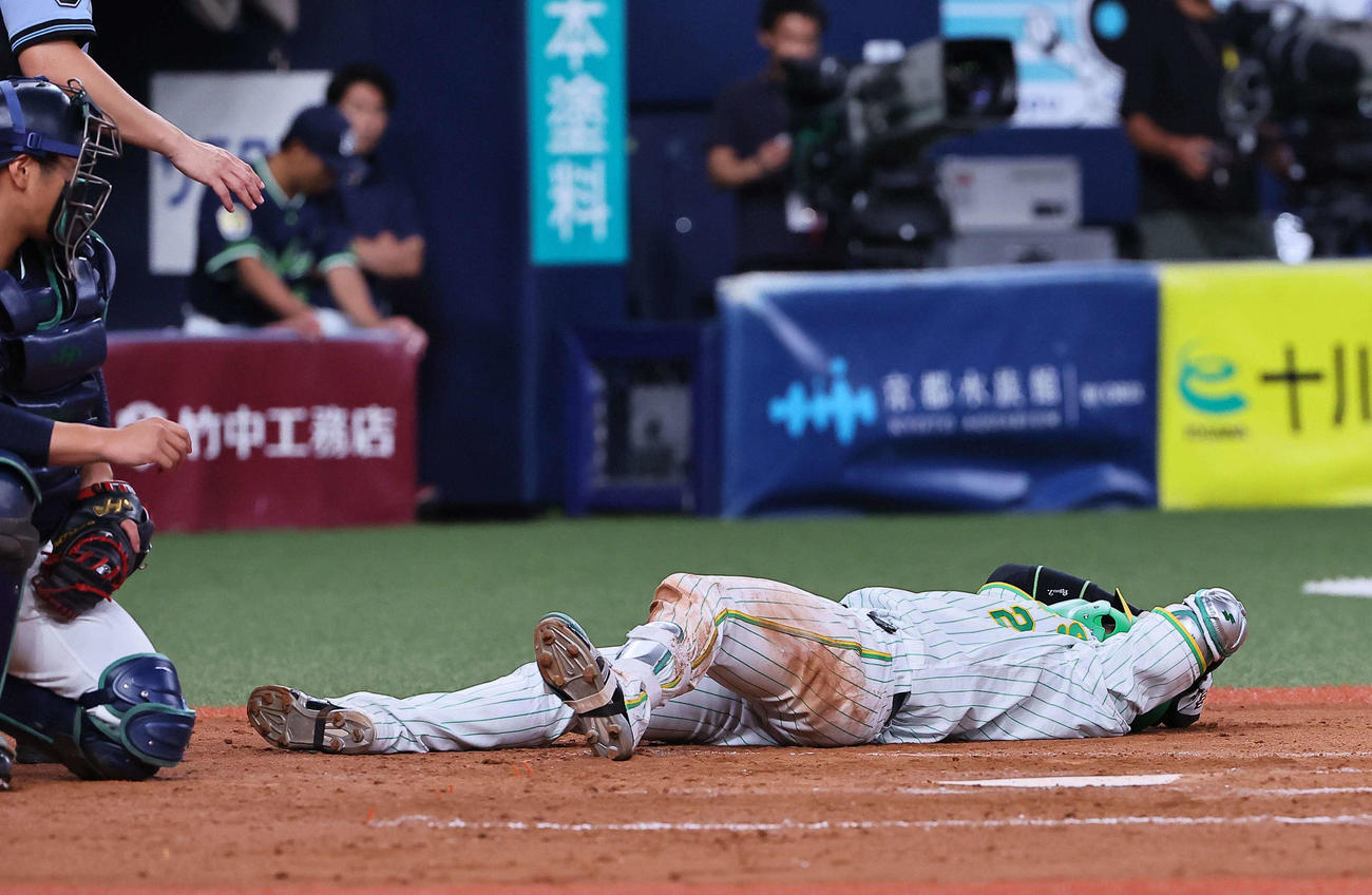 阪神対ヤクルト　5回裏阪神1死、左手に死球を受ける梅野（撮影・上田博志）