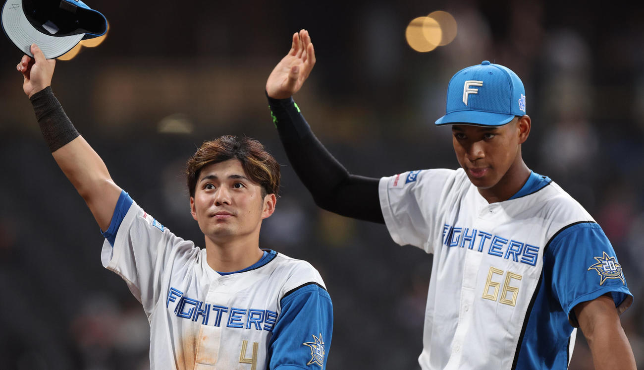 日本ハム対ロッテ　スタンド応援席のファンに手を振りながらグラウンドを一周する日本ハム上川畑（左）と万波（撮影・佐藤翔太）