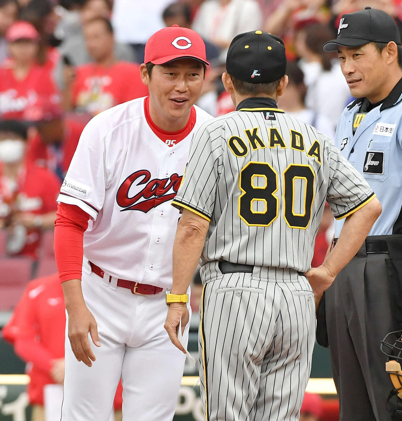 広島対阪神　メンバー表交換で阪神岡田監督（右）と笑顔で話す広島新井監督（撮影・岩下翔太）