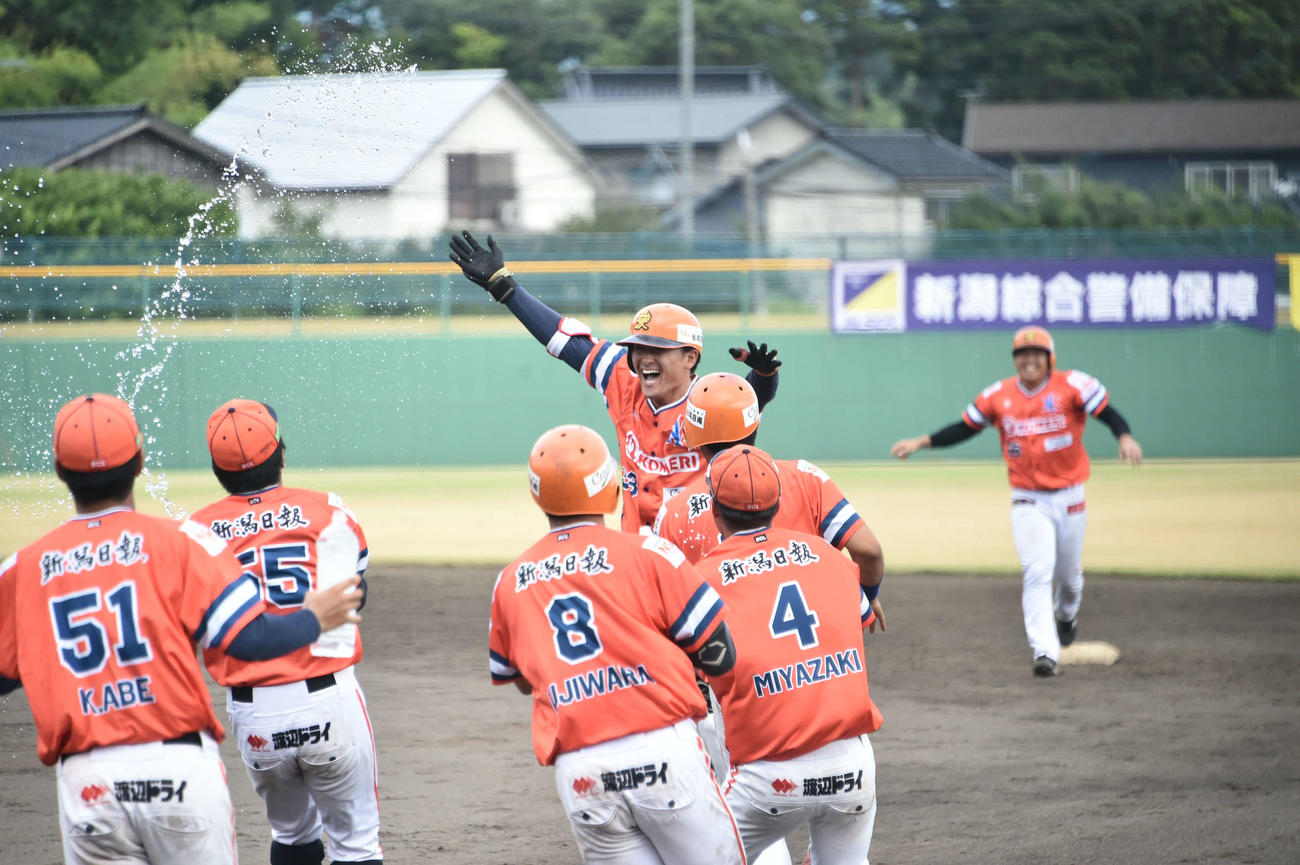 新潟対群馬　9回裏1死一、三塁で左前にサヨナラ打を放った新潟・番場は両手を広げながら駆け寄ったチームメートと喜び合う